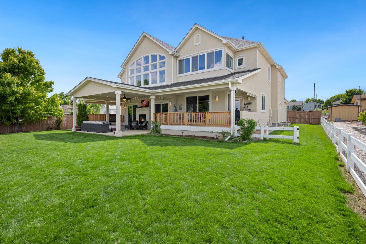A two-story house with a covered porch and a large green lawn